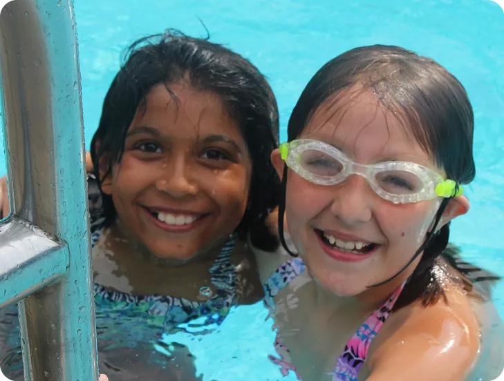 two girls smiling in the pool