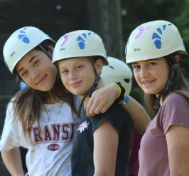 three girls posing in front of climbing wall