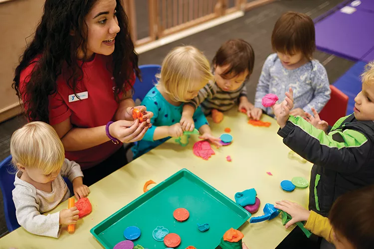 Staff member playing with group of kids
