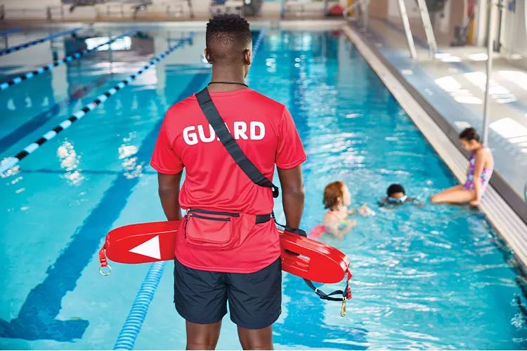 Lifeguard standing near pool