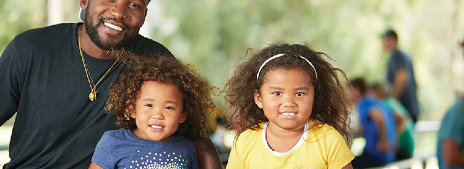 Father sitting with two daughters