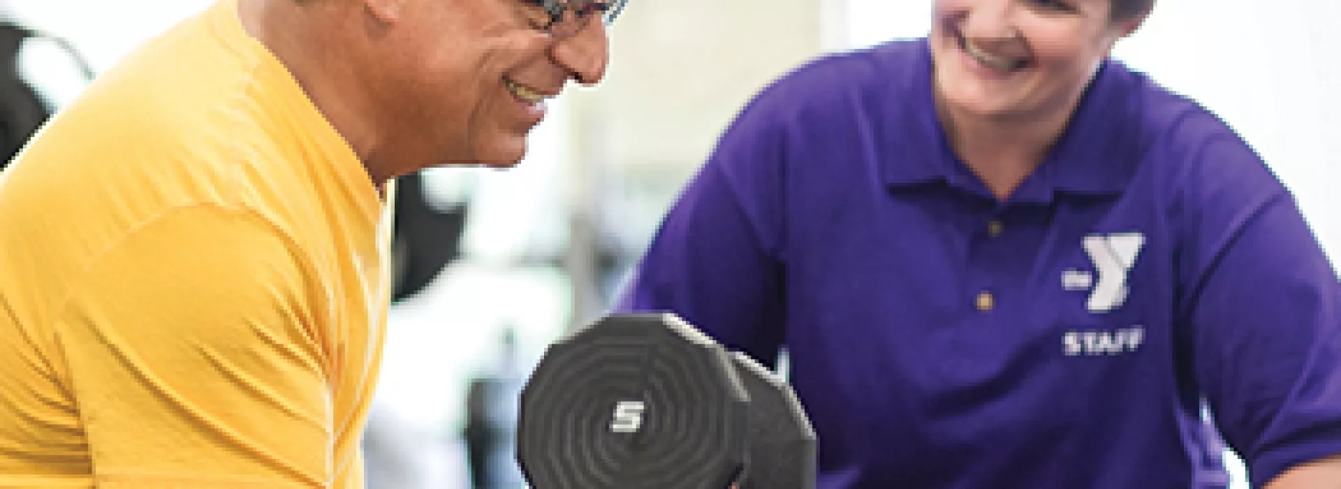 Man and Personal Trainer lift a dumbbell together