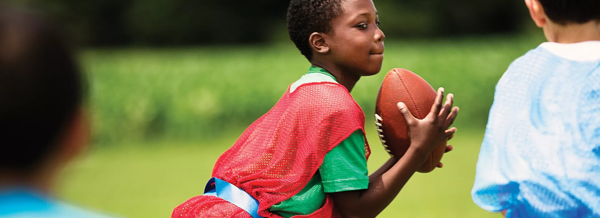 boy running with football