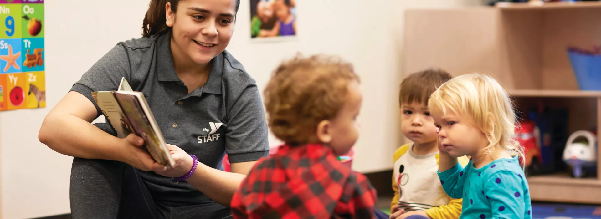 staff member reading to toddlers