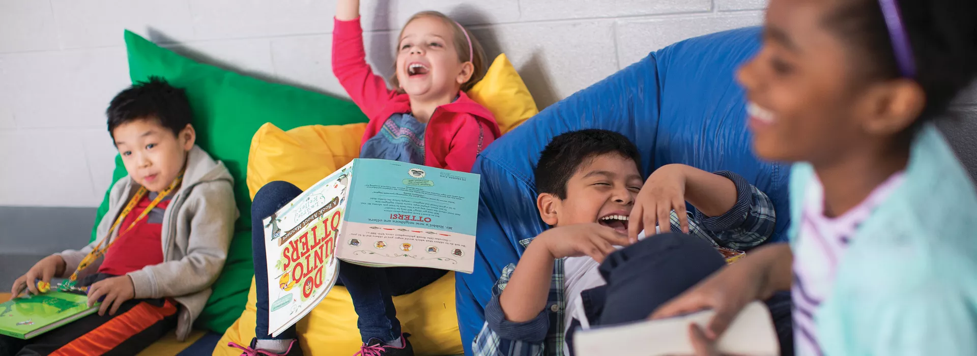 group of children laughing and reading