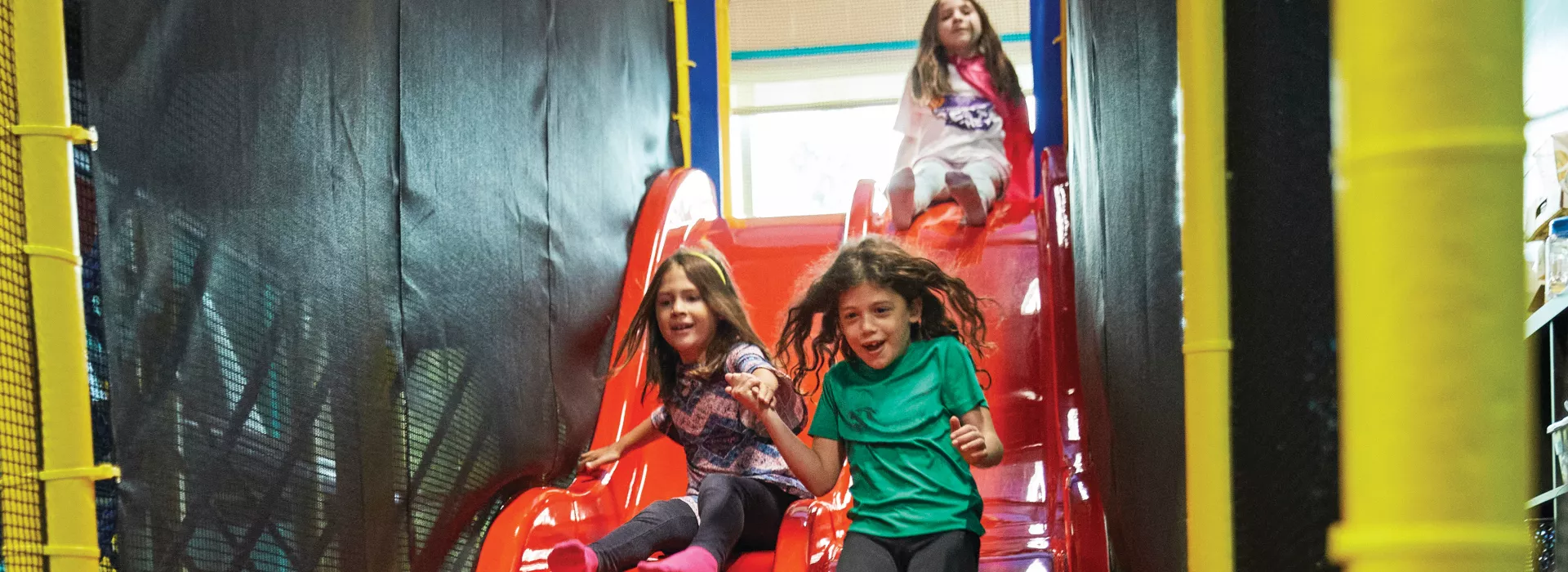 three girls going down the slide