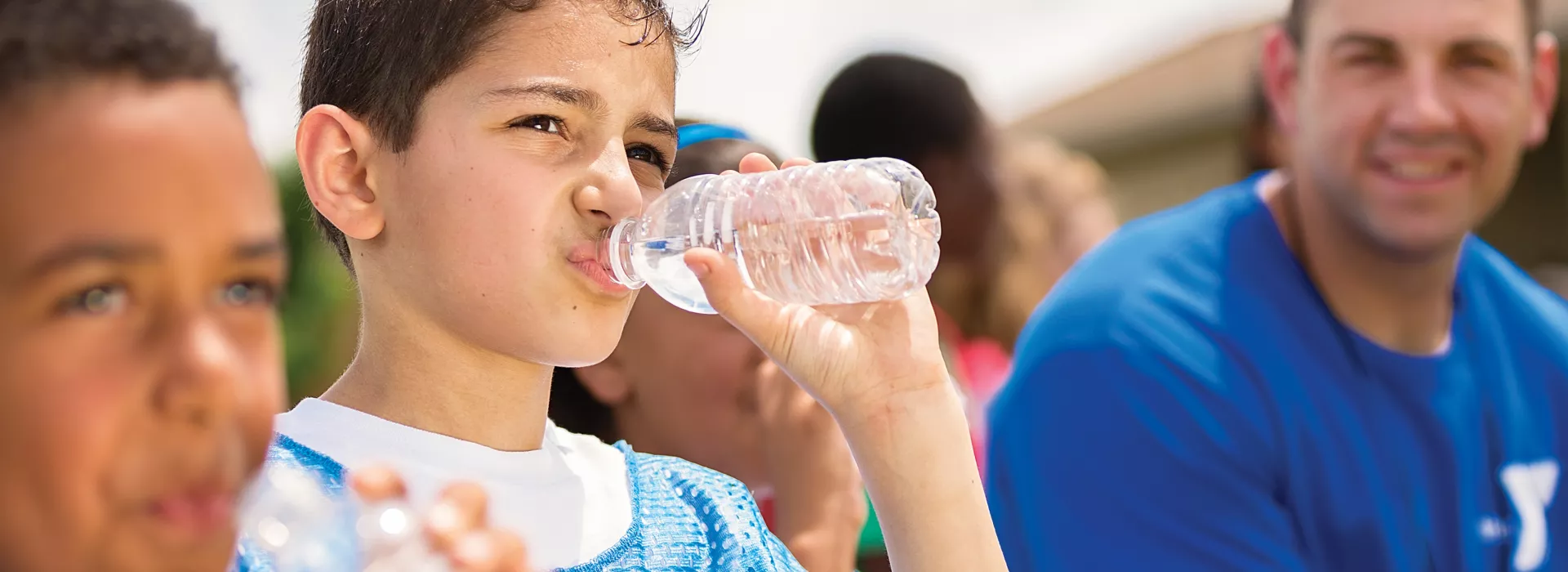two boys sitting on bench with coach