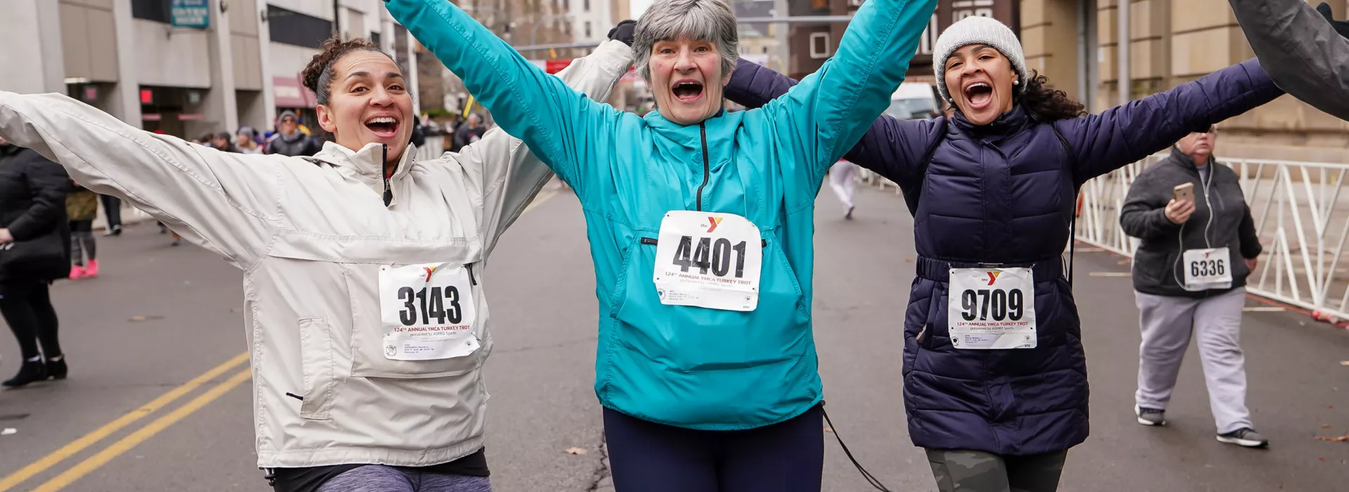 Three women pose for a photo along the race route